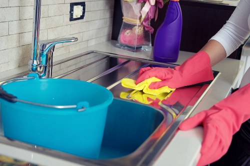 Kitchen surfaces and appliances being cleaned during a one-off cleaning visit in E1