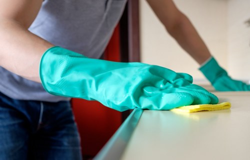 Local cleaner vacuuming and mopping floors in a modern E1 flat