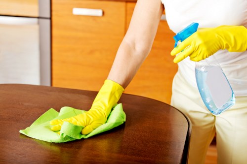 Professional cleaner tidying a kitchen in an E1 Airbnb property